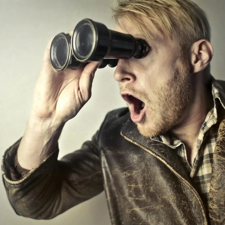 man in brown leather jacket using binoculars