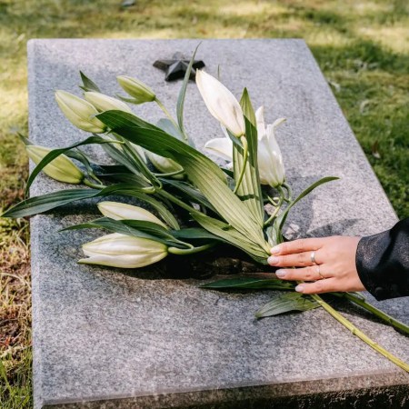 laying flowers over a tombstone